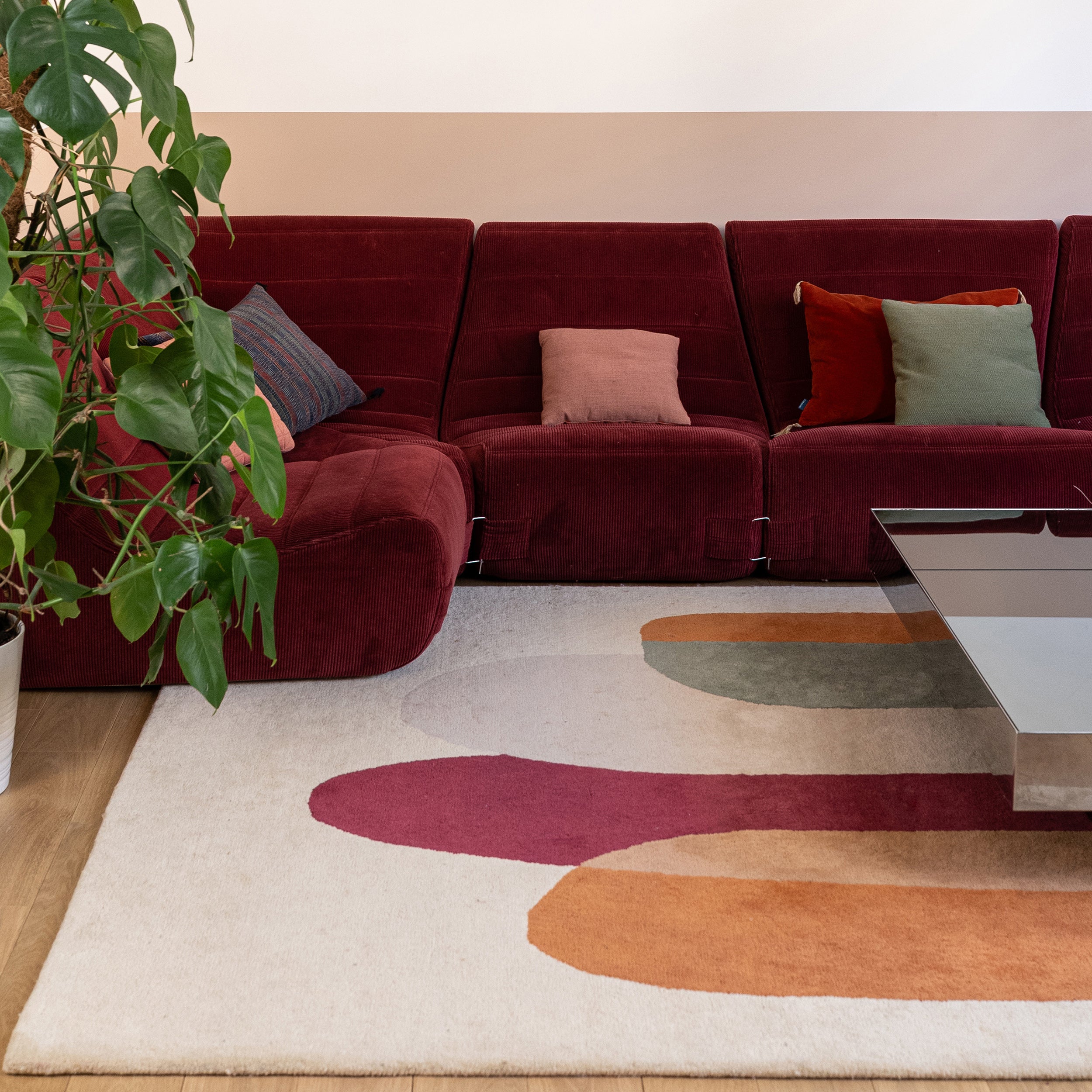 Tapis multicolore en laine et canapé bordeaux