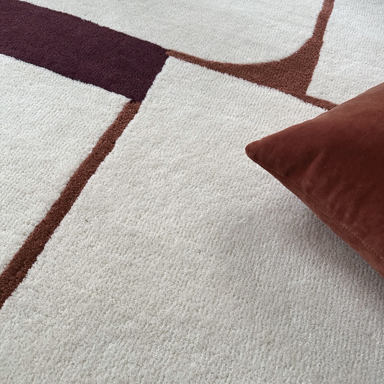 Zoom texture tapis laine blanc et bordeaux