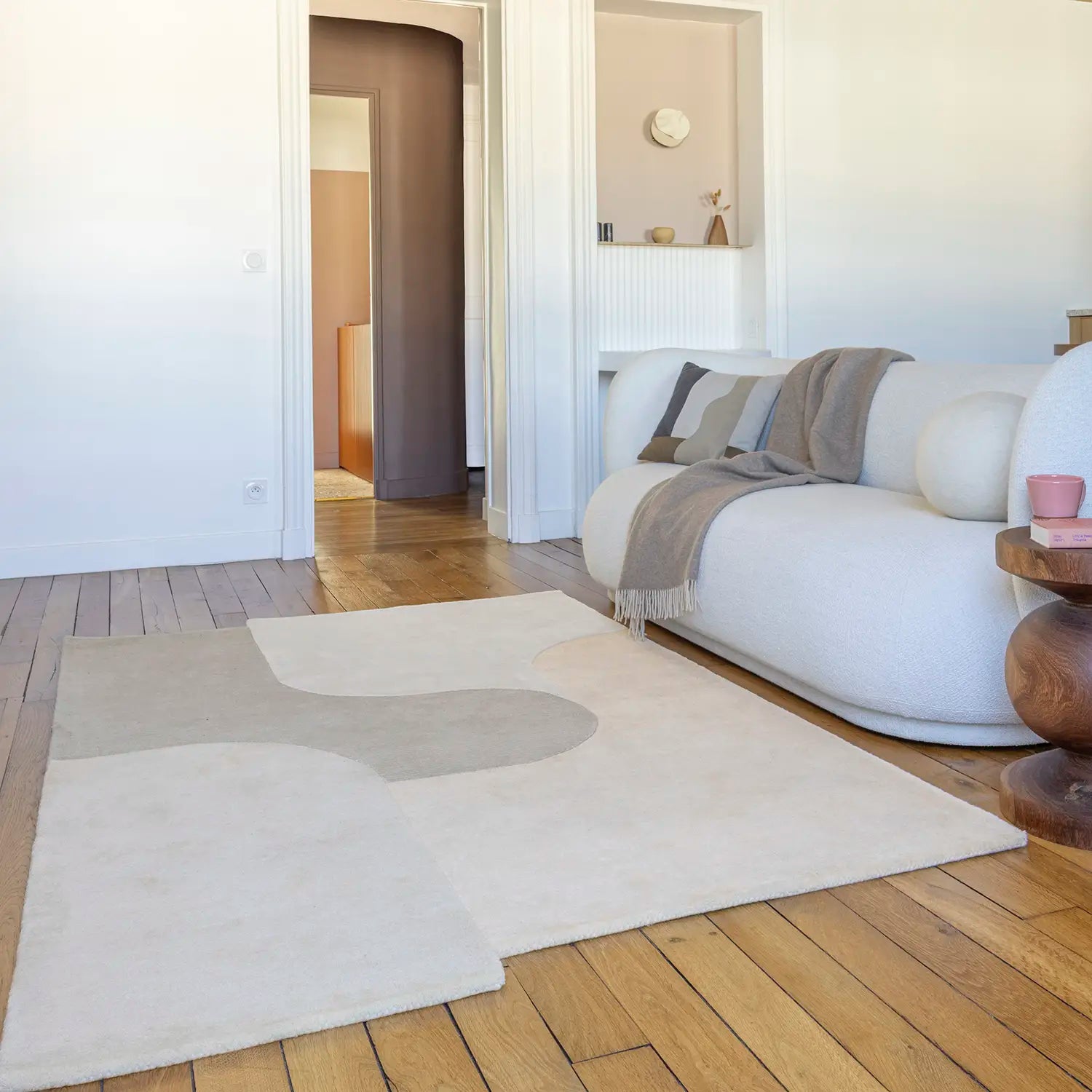Tapis beige en laine devant canapé blanc