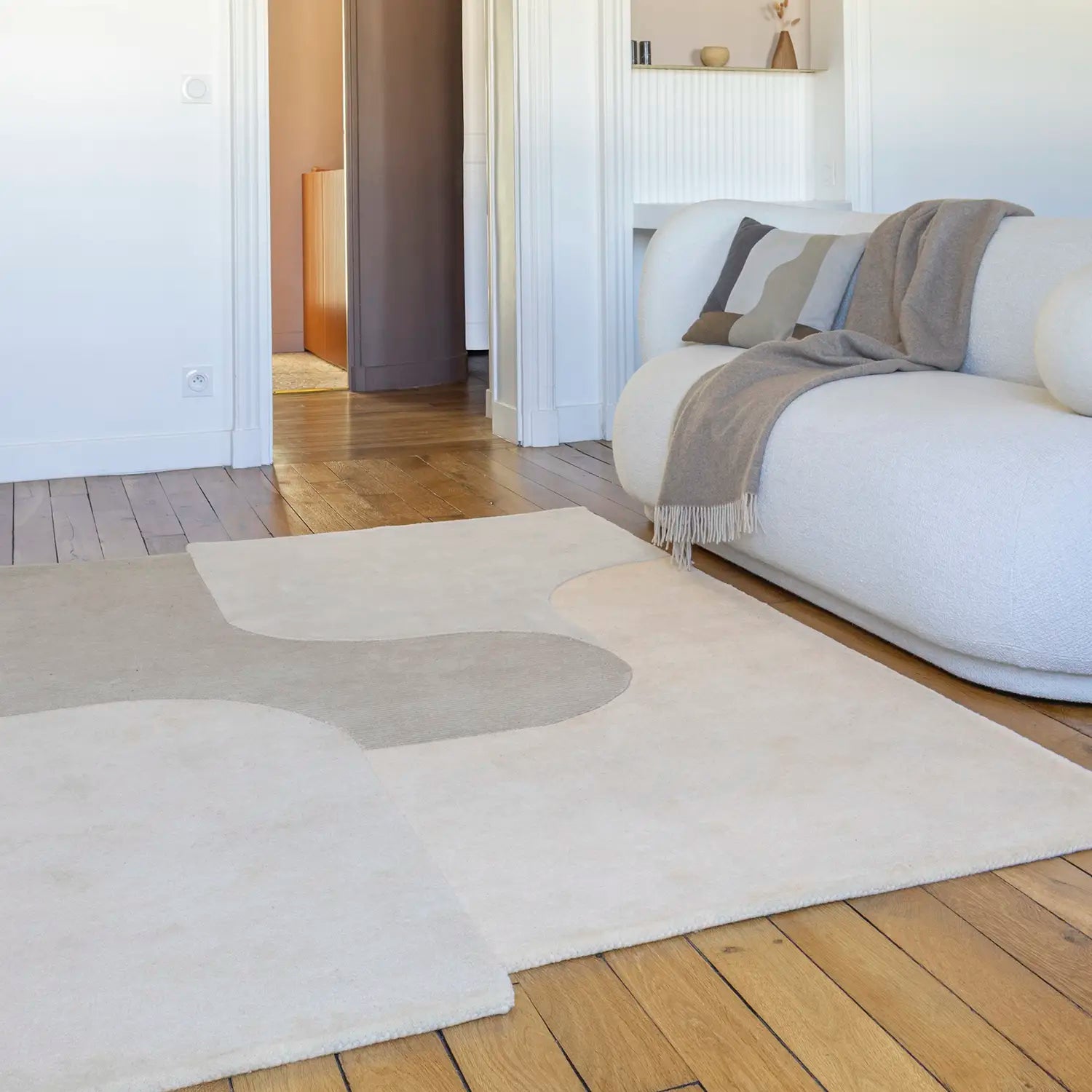 Tapis en laine beige et canapé blanc