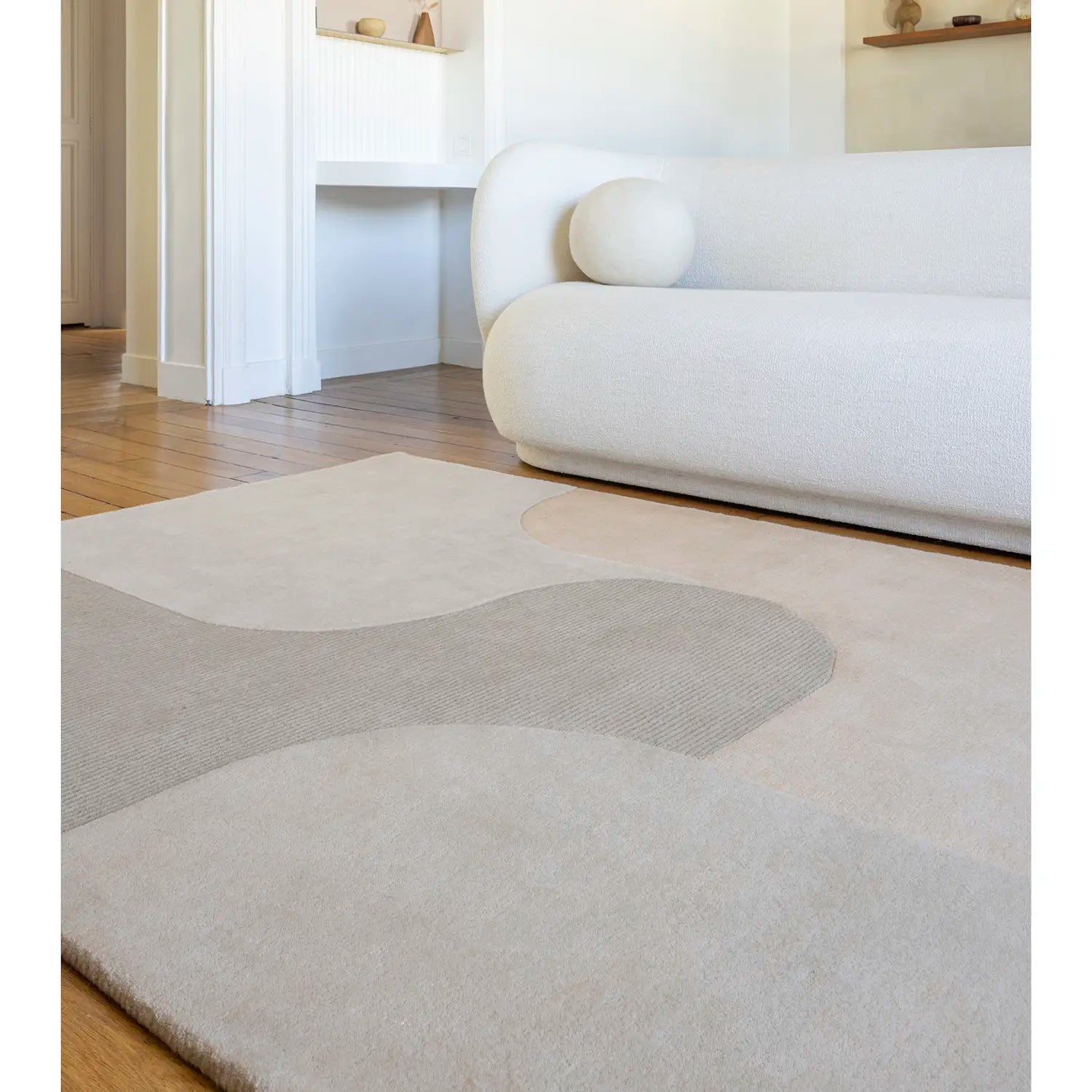 Tapis beige devant canapé blanc