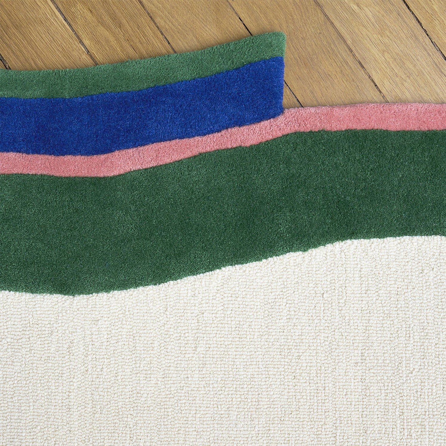 Zoom texture tapis en laine vert, bleu, rose et blanc
